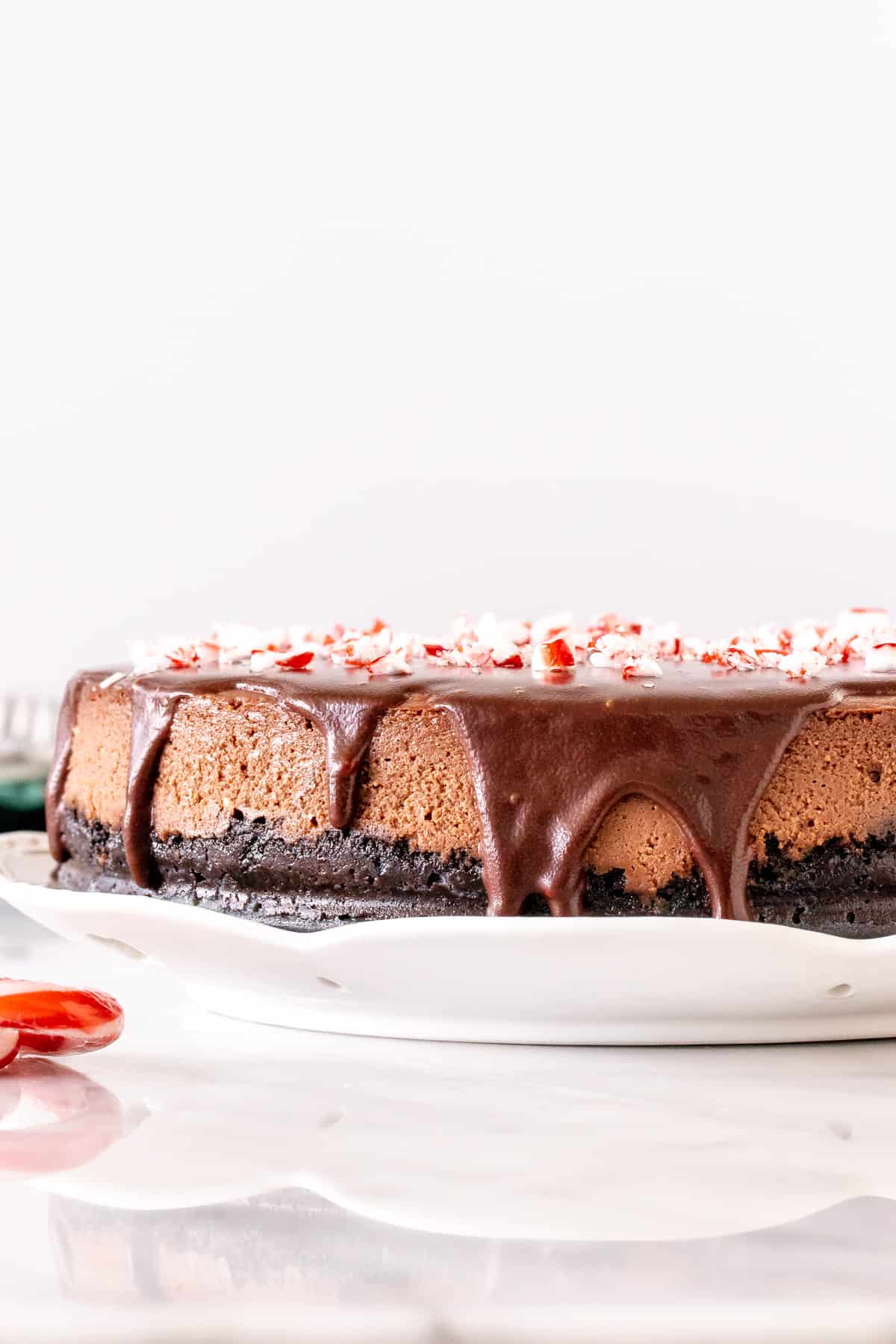 Chocolate cheesecake with chocolate on top and crushed candy canes.