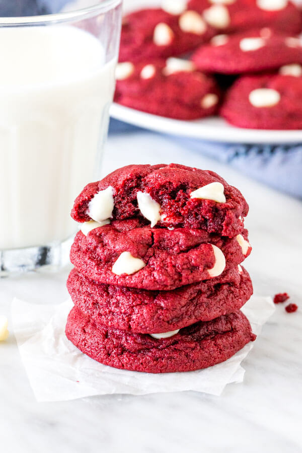 Stack of 4 red velvet cake mix cookies with a glass of milk. 
