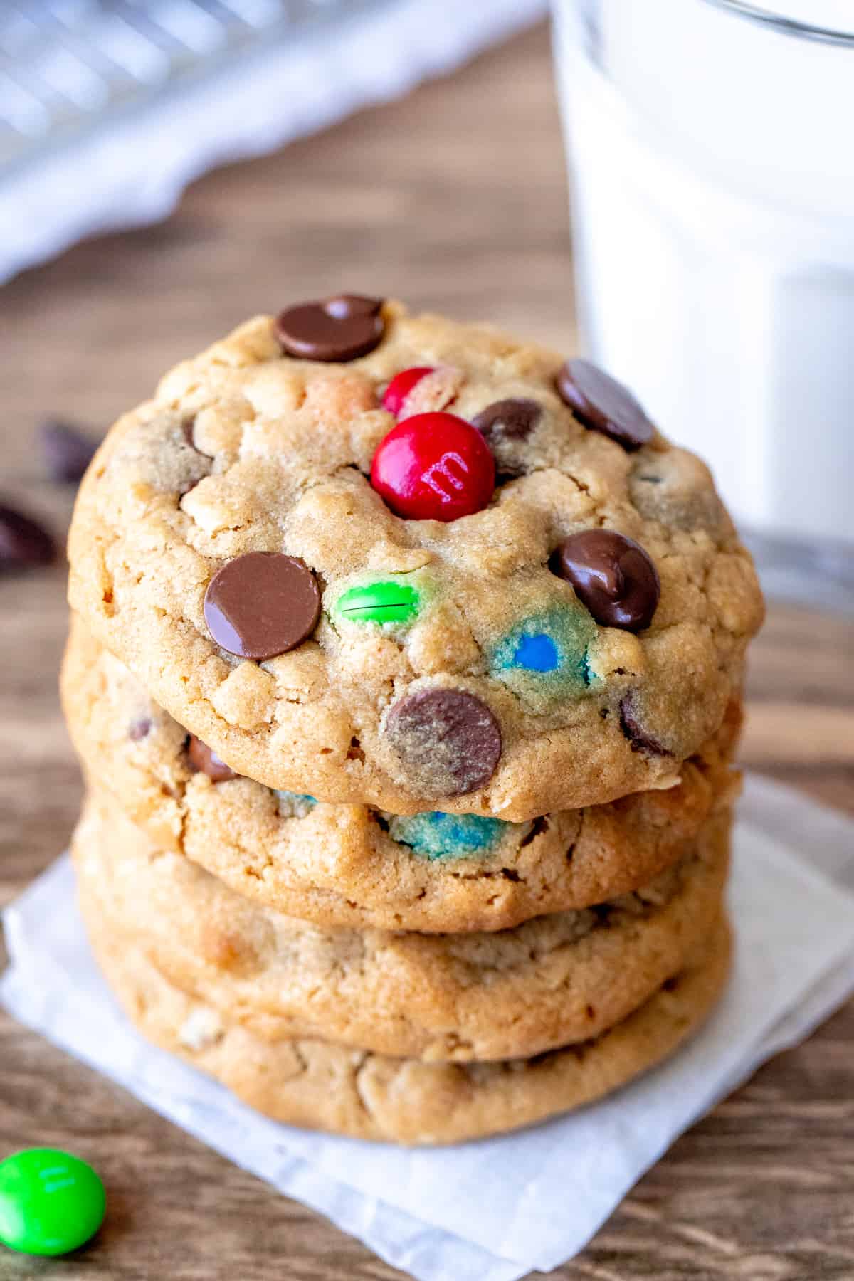 Stack of peanut butter M&M cookies with glass of milk