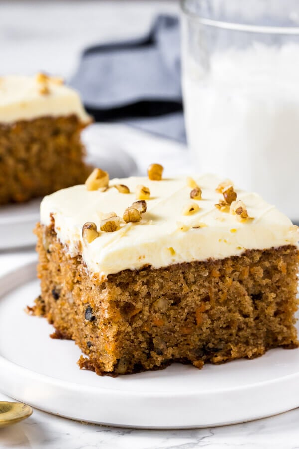 A slice of moist carrot cake with cream cheese frosting - the perfect, easy carrot cake recipe. 