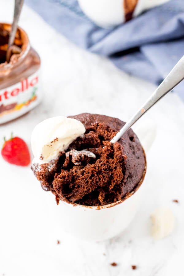 A spoonful of warm, gooey Nutella mug cake with vanilla ice cream. 