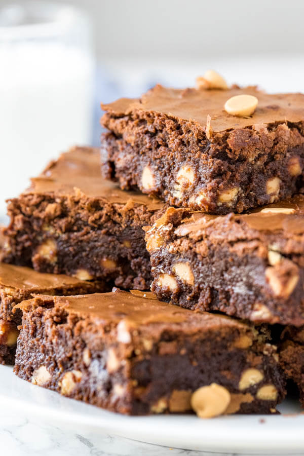 A plate of chocolate peanut butter brownies filled with peanut butter chips. 