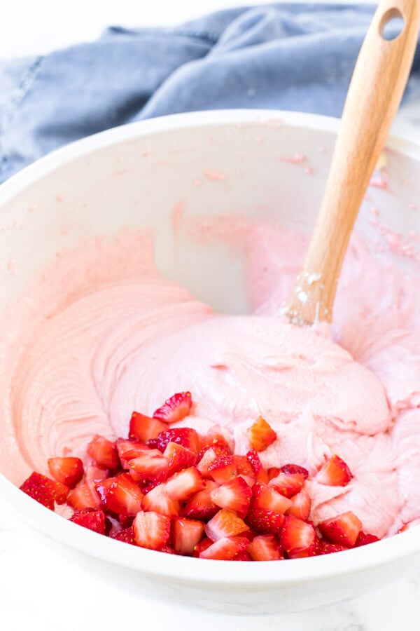 A bowl of strawberry cupcake batter made with strawberry puree and real strawberry pieces. 