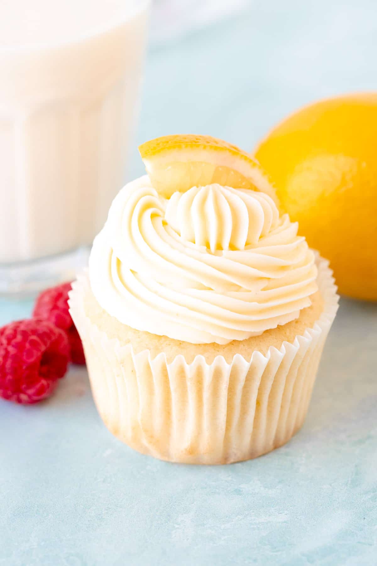 Lemon cupcake with lemon frosting with glass of milk