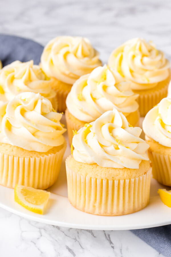 A plate of lemon cupcakes with lemon frosting. 