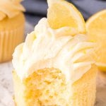 A moist, fluffy lemon cupcake with a bite taken out of it.
