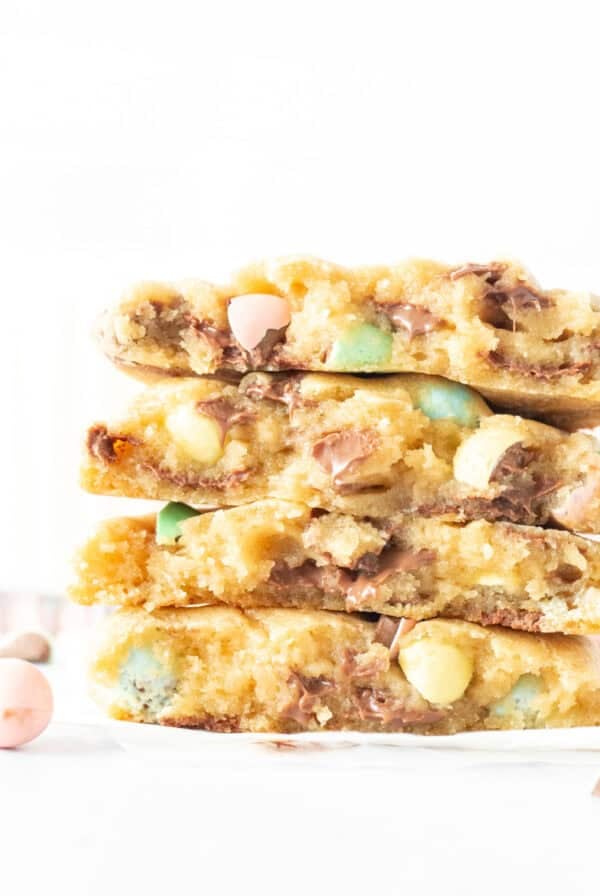 Easter candy chocolate chip cookies, broken in half and stacked one on top of another