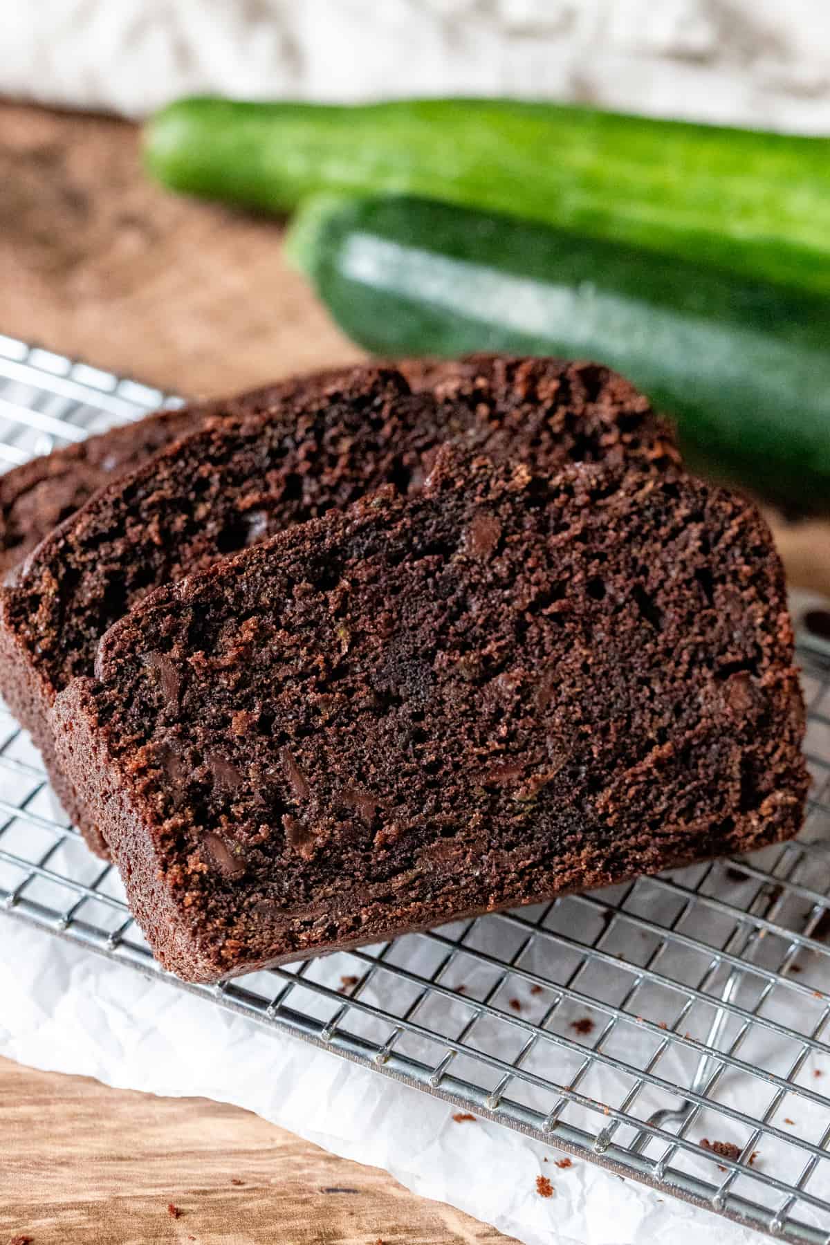 Slices of moist chocolate zucchini bread on wire cooling rack