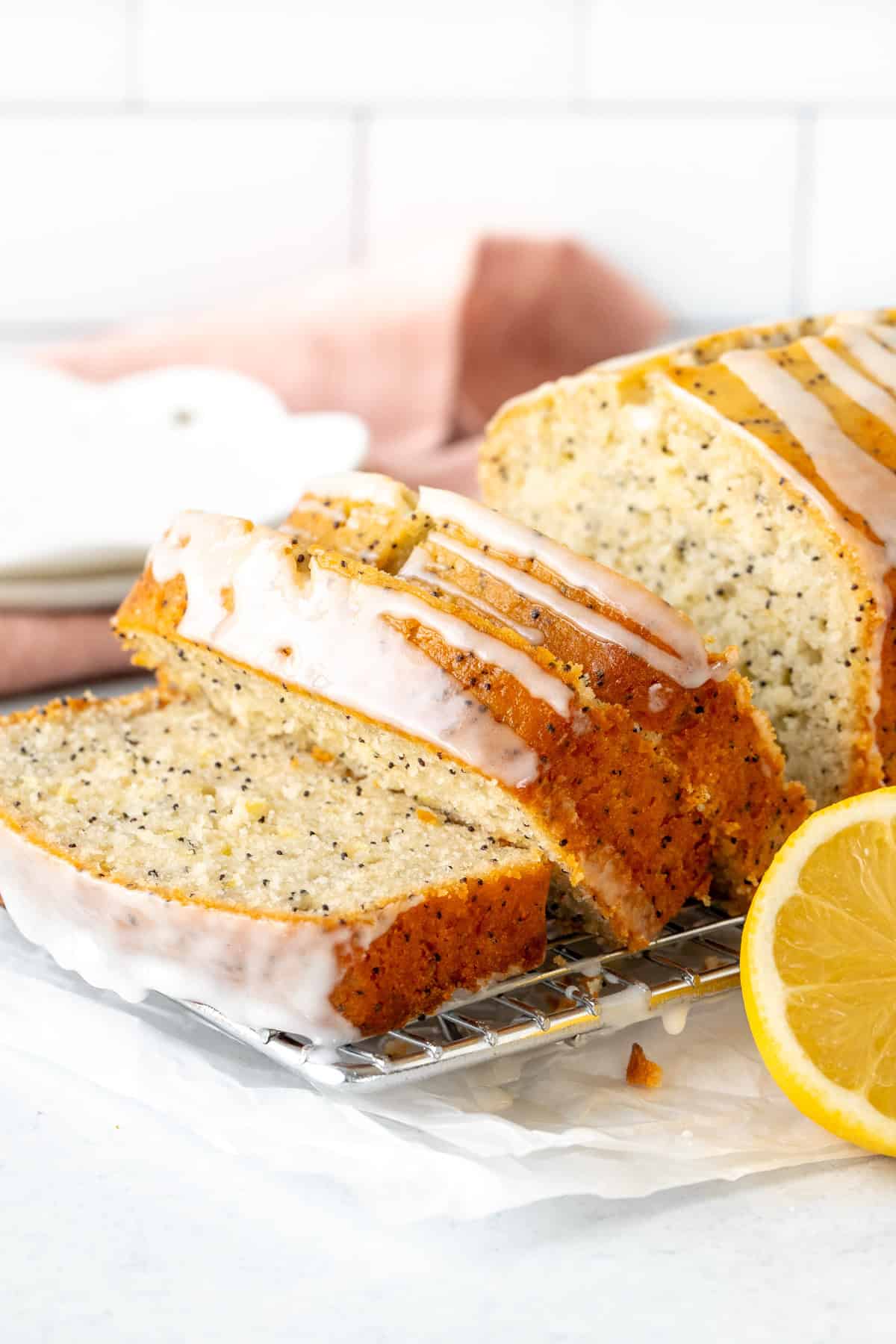 3 slices of lemon poppy seed bread with lemon glaze on a cooling rack