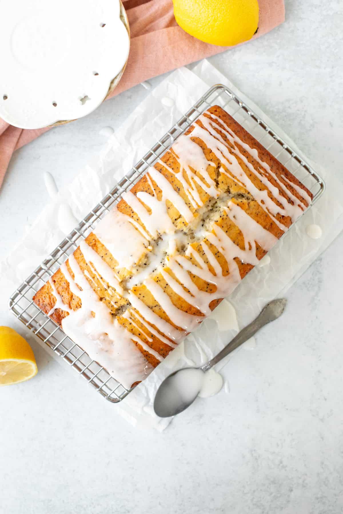 Lemon poppy seed loaf drizzled with lemon glaze, on a cooling rack