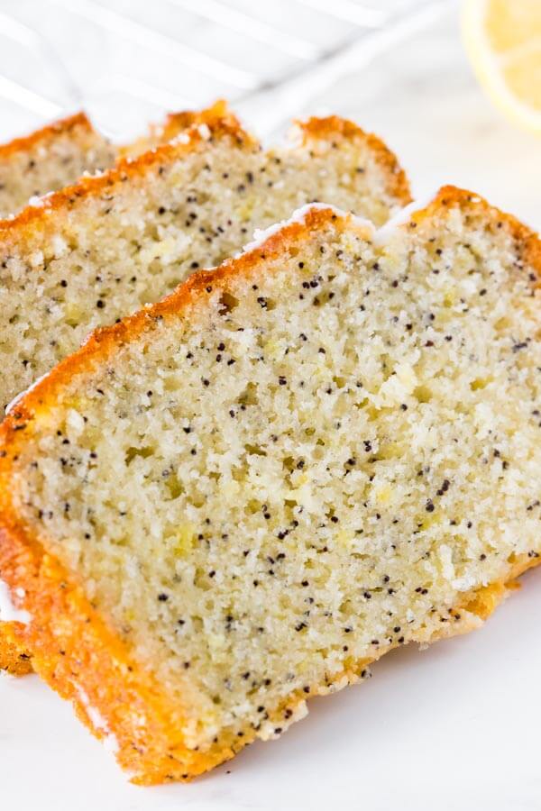 Close up shot of 3 slices of lemon poppy seed bread that's moist, tender and filled with fresh lemon flavor. 