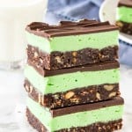 A stack of 3 mint Nanaimo bars shot from the side to see the 3 layers.