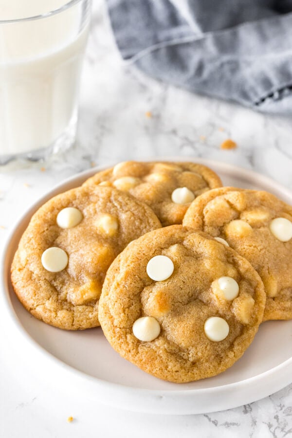 A plate of chewy white chocolate chip cookies. 