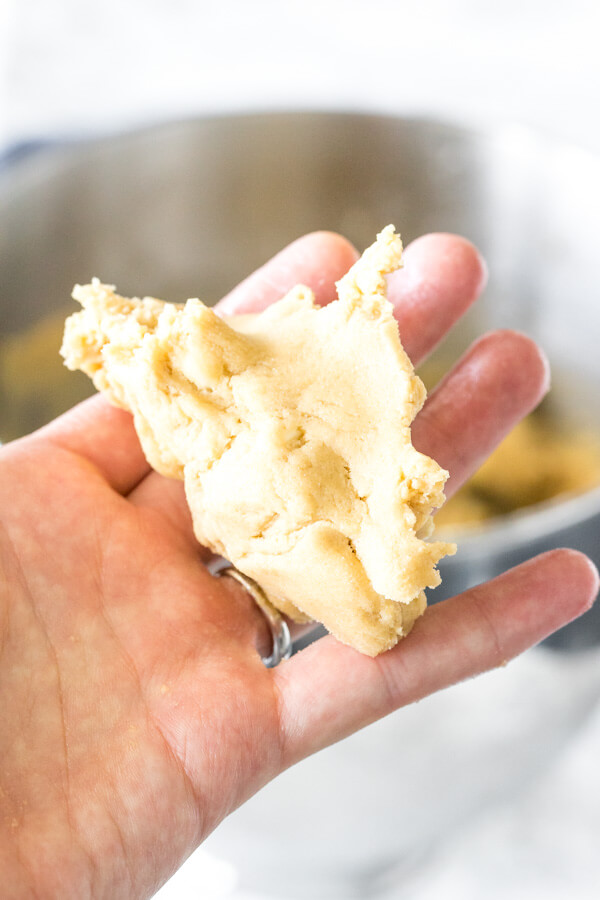 White chocolate chip cookie dough after being squeezed in a palm. 