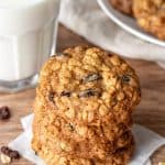 Oatmeal raisin cookies, one on top of each other with glass of milk