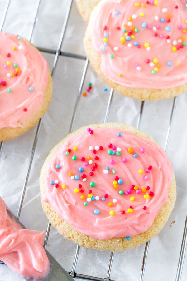 A round sugar cookie with pink frosting and sprinkles