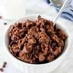 A bowl of edible double chocolate cookie dough with a spoon in it.