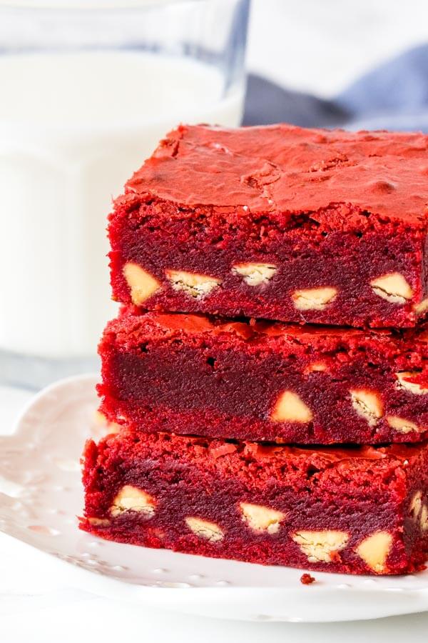 Close up of a stack of 3 red velvet brownies stacked one of top of each other.