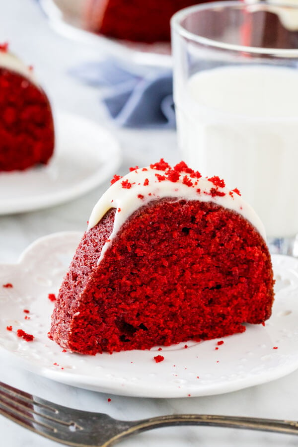 A slice of moist red velvet bundt cake with cream cheese glaze. 