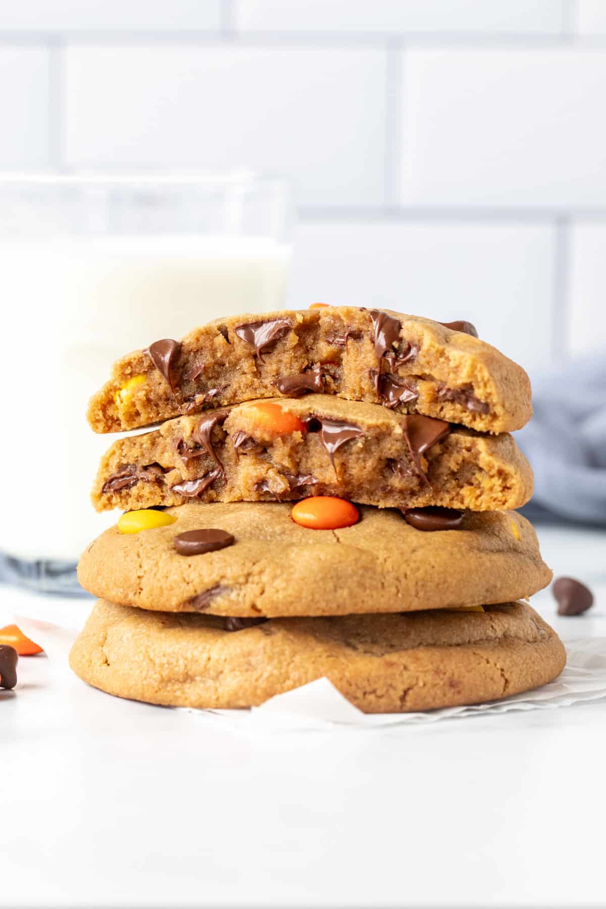 Stack of Reese's Pieces peanut butter cookies, with the top cookie broken in half.