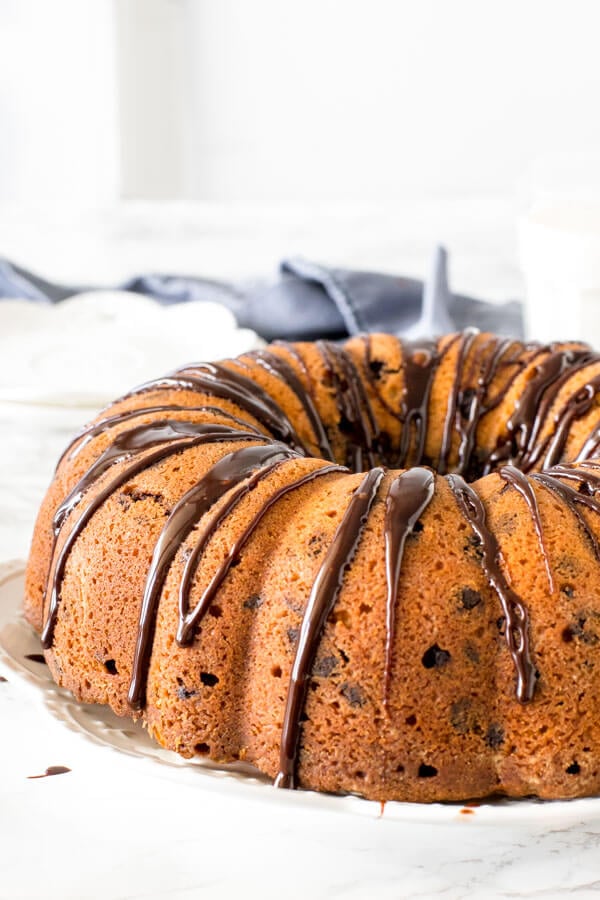 Bundt cake drizzled with chocolate ganache on a plate. 
