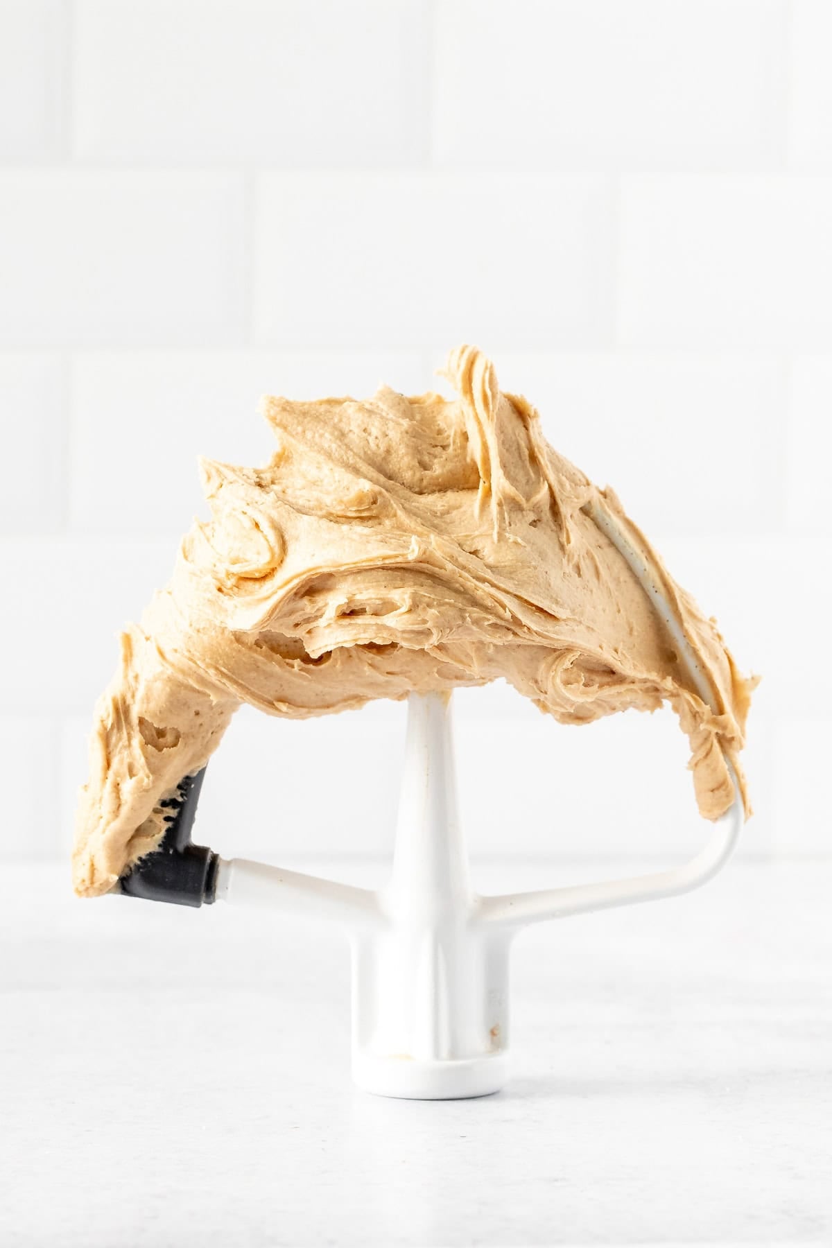 Paddle attachment of kitchen mixer with peanut butter frosting