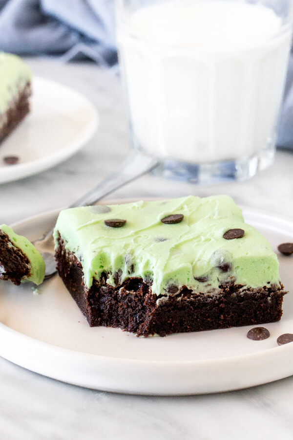 Mint chip brownie with a bite taken out of it on a plate with a fork. 