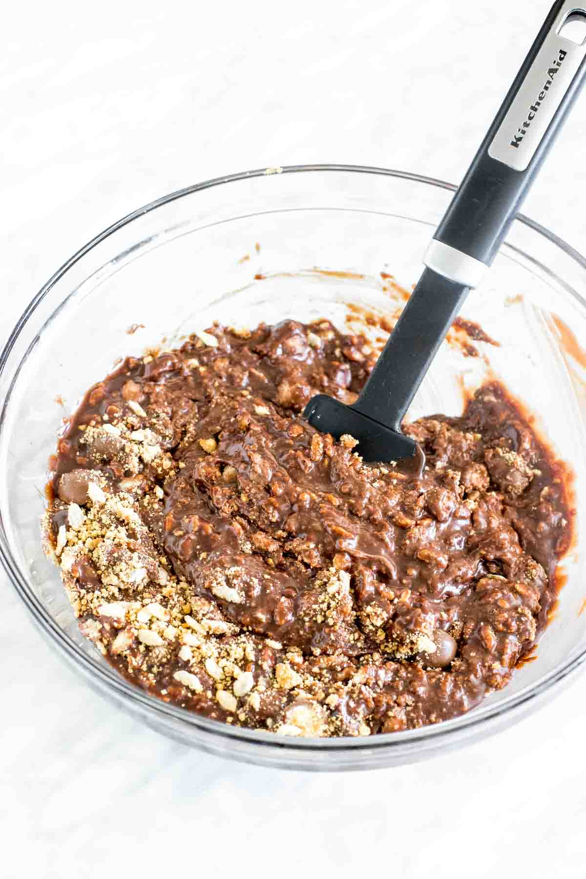 Chocolate fudge poured cereal, crushed biscuits, and candies in a bowl. 