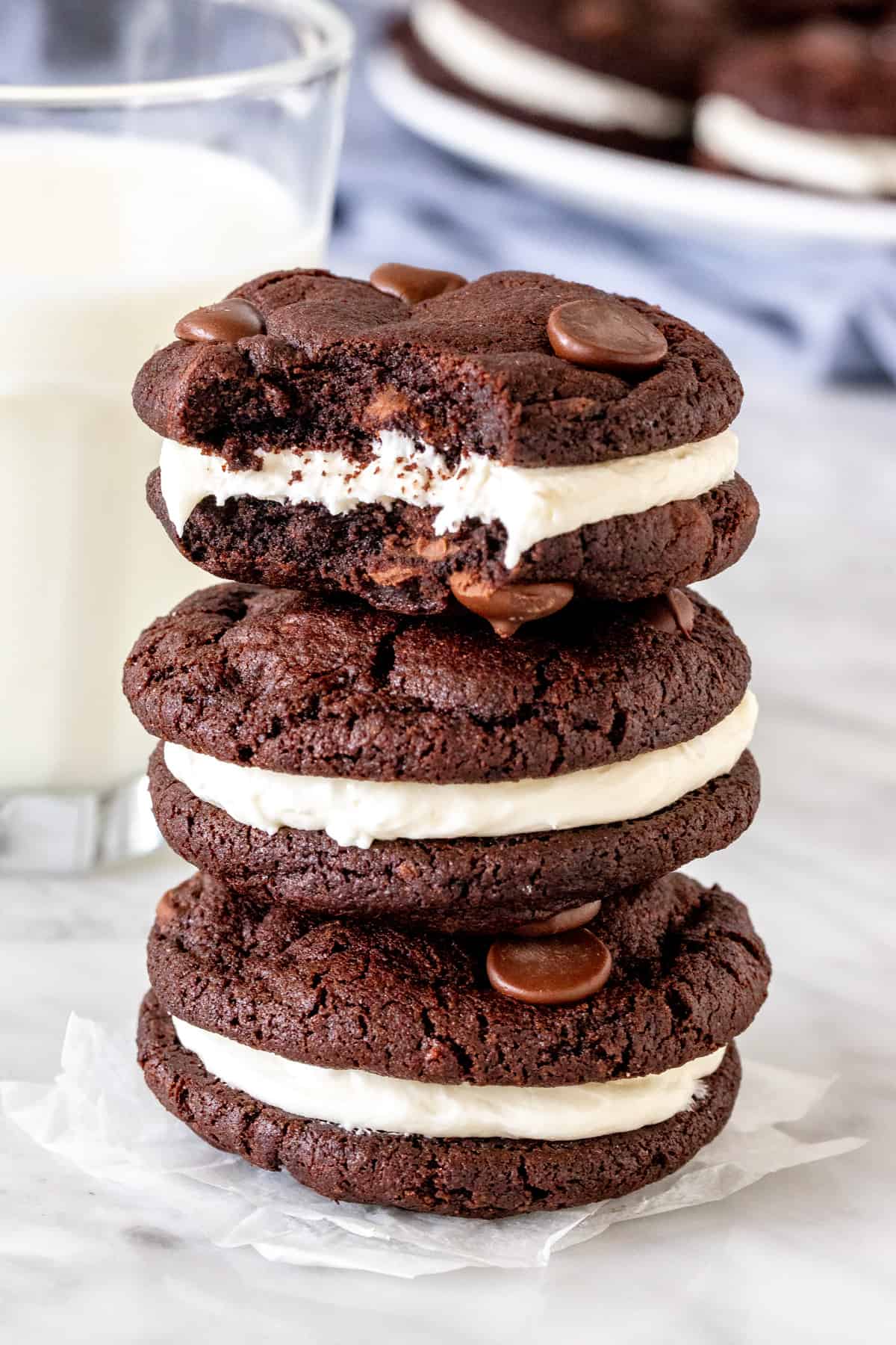 Stack of three chocolate cookies with vanilla frosting. 