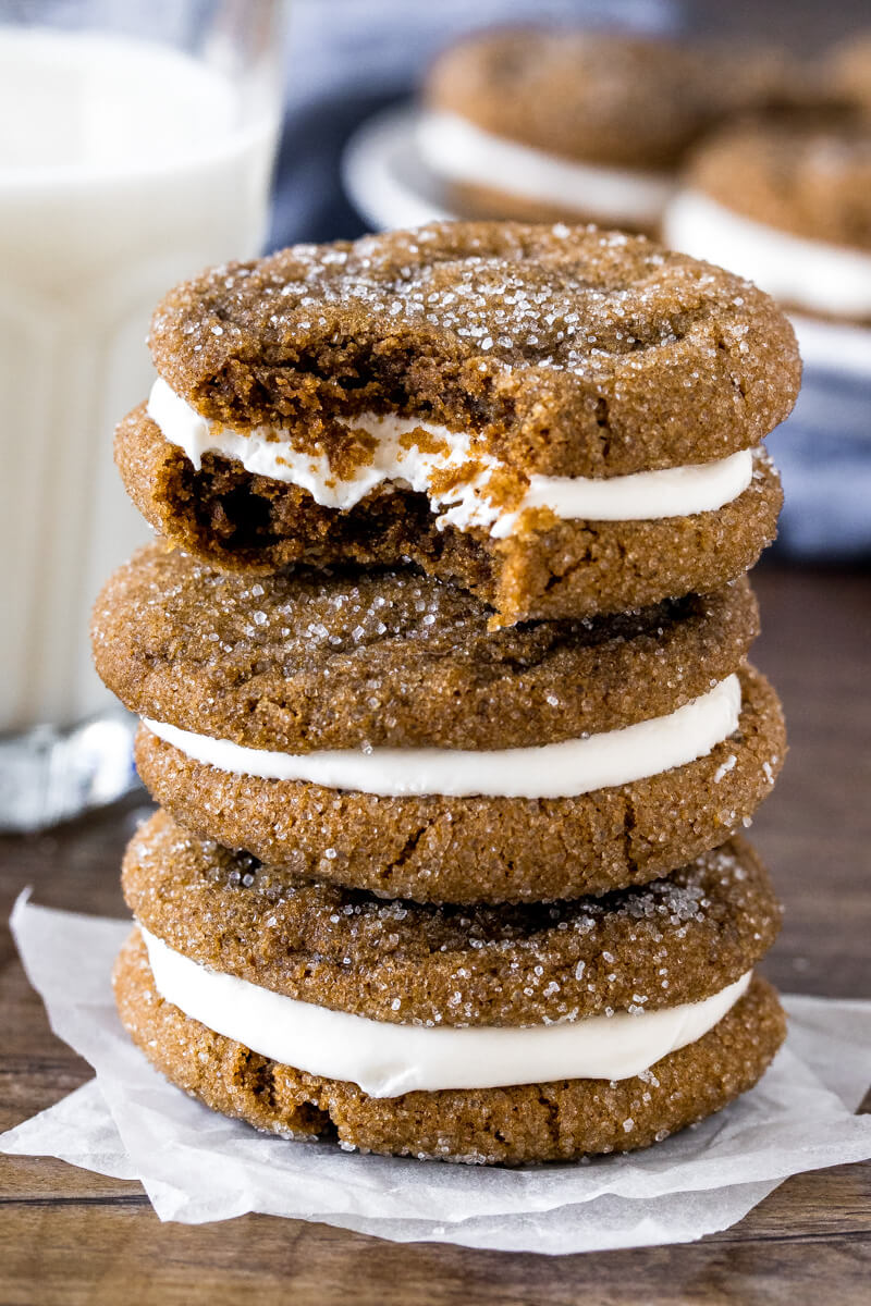 Stack of 3 ginger molasses sandwich cookies, with a bite taken out of the top cookie. 
