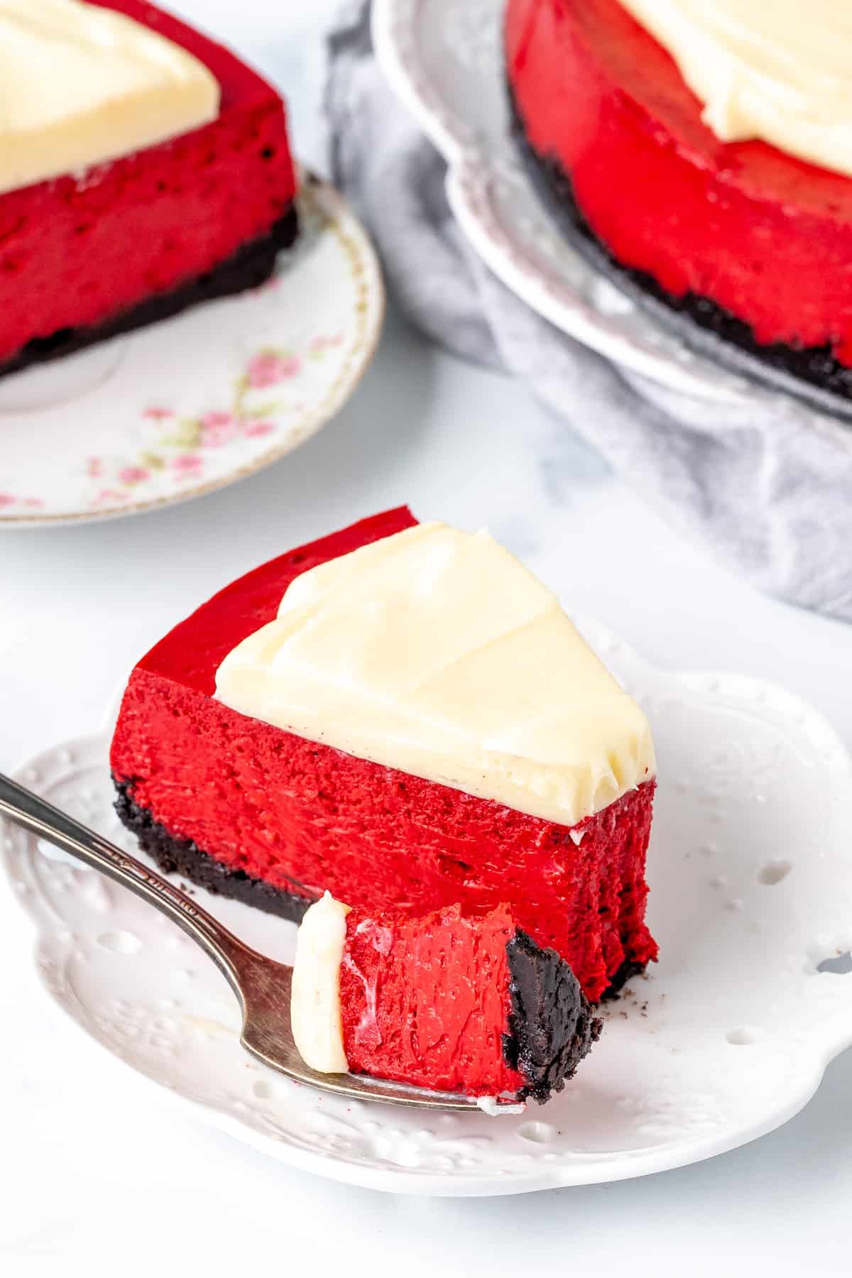 Slice of red velvet cheesecake with a bite taken out of it