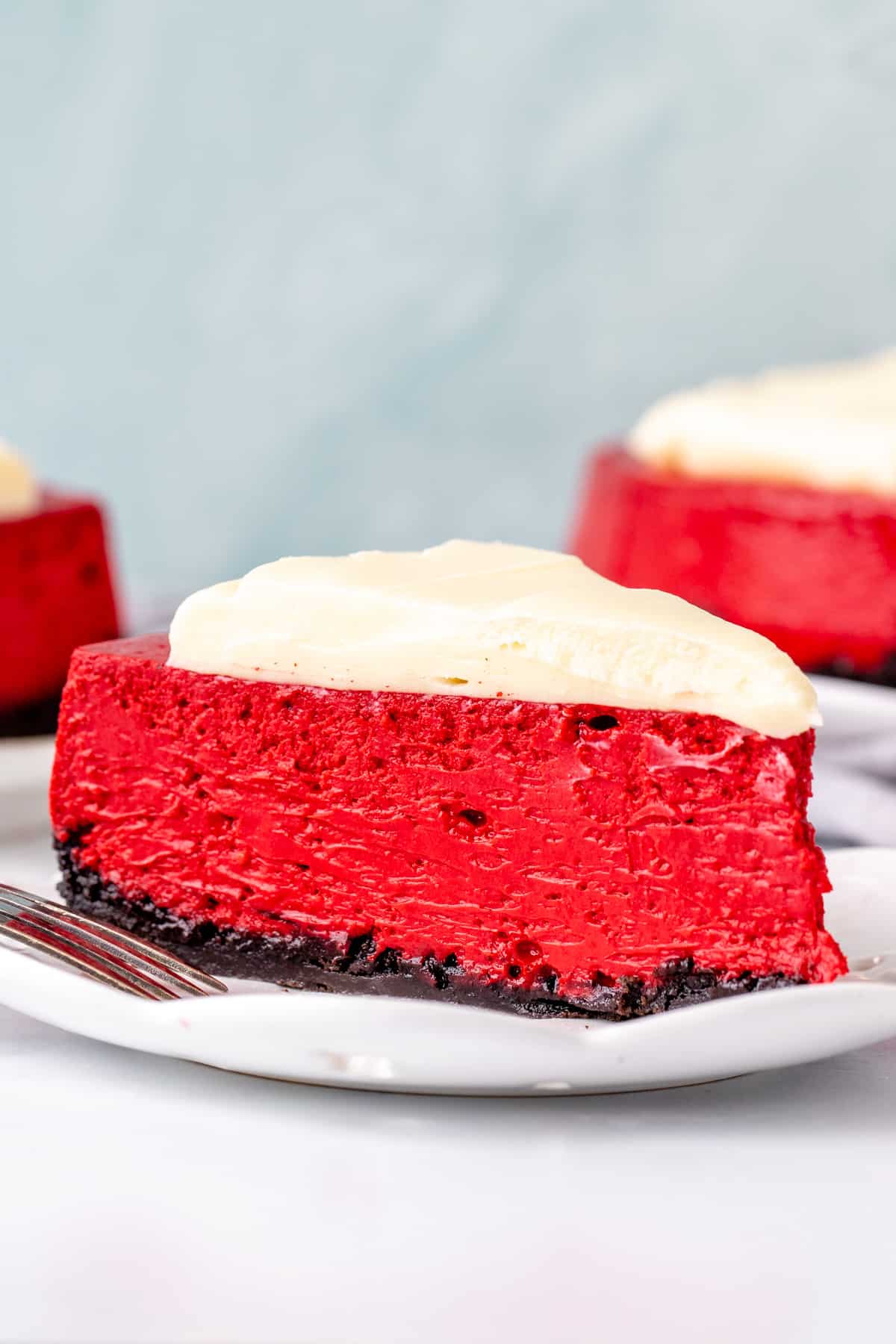Slice of red velvet cheesecake with cream cheese topping