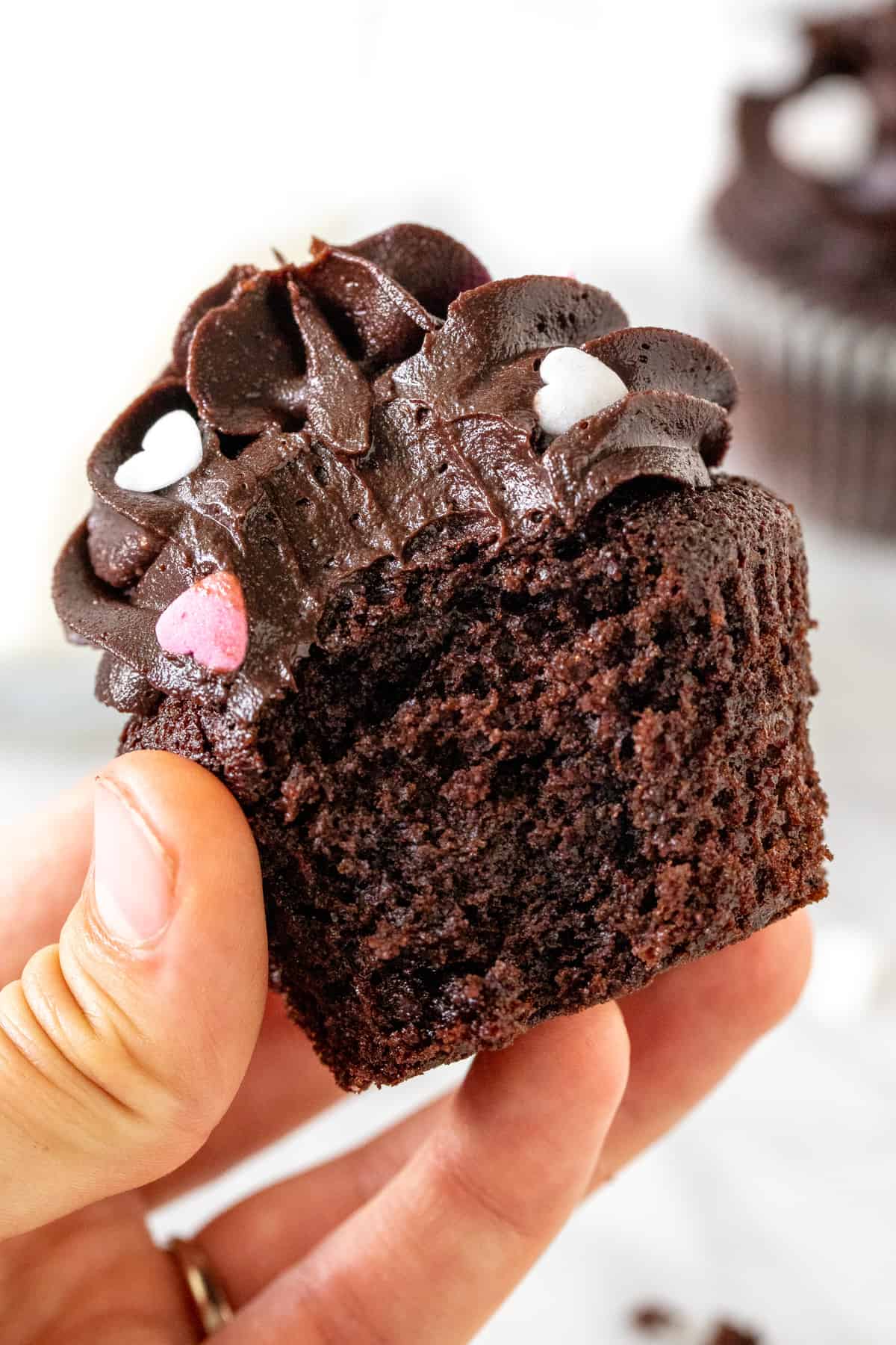 A chocolate cupcake with a bite taken out of it.