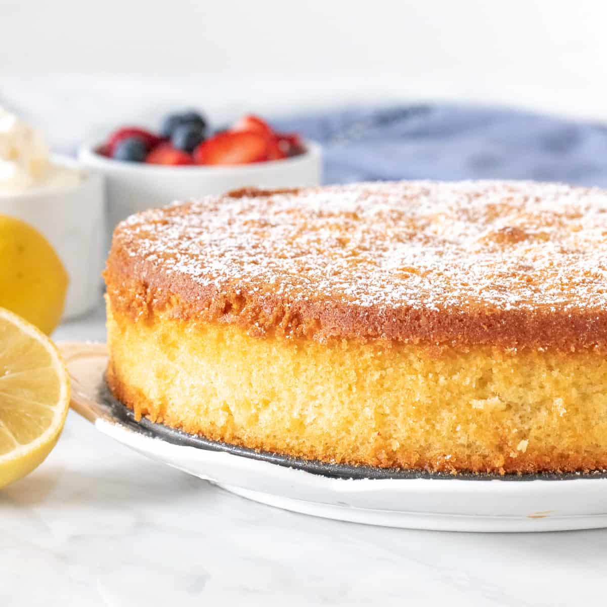 Round lemon olive oil cake with a sprinkle of powdered sugar.