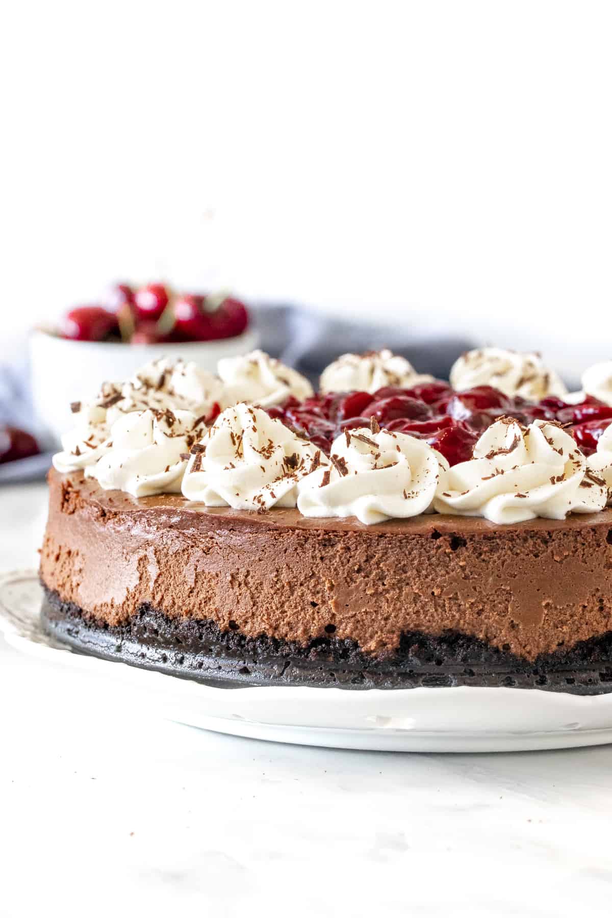 Black forest cheesecake with whipped cream and cherries on top