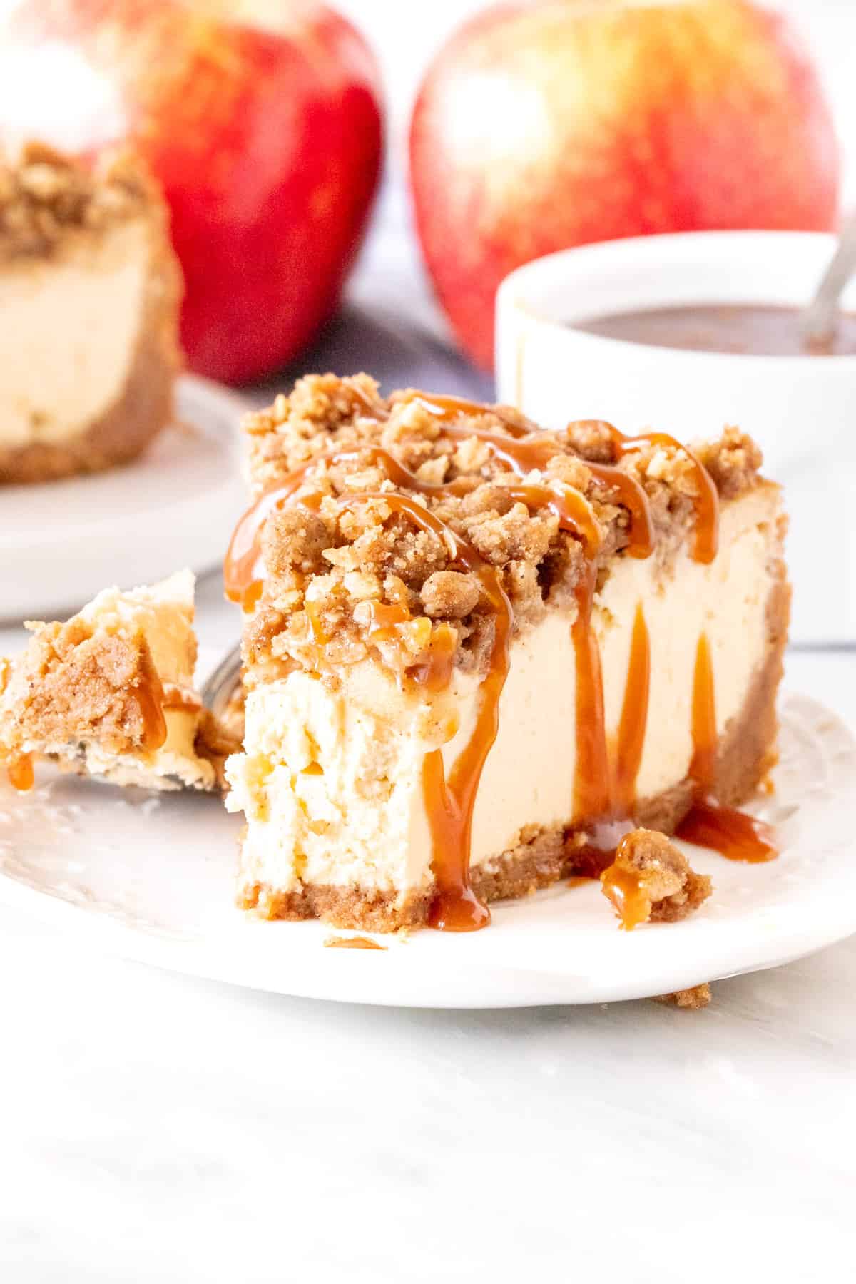 Slice of caramel apple crumble cheesecake with a bite taken out