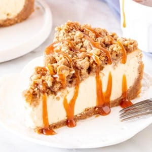 Slice of apple crisp cheesecake with a drizzle of caramel sauce.