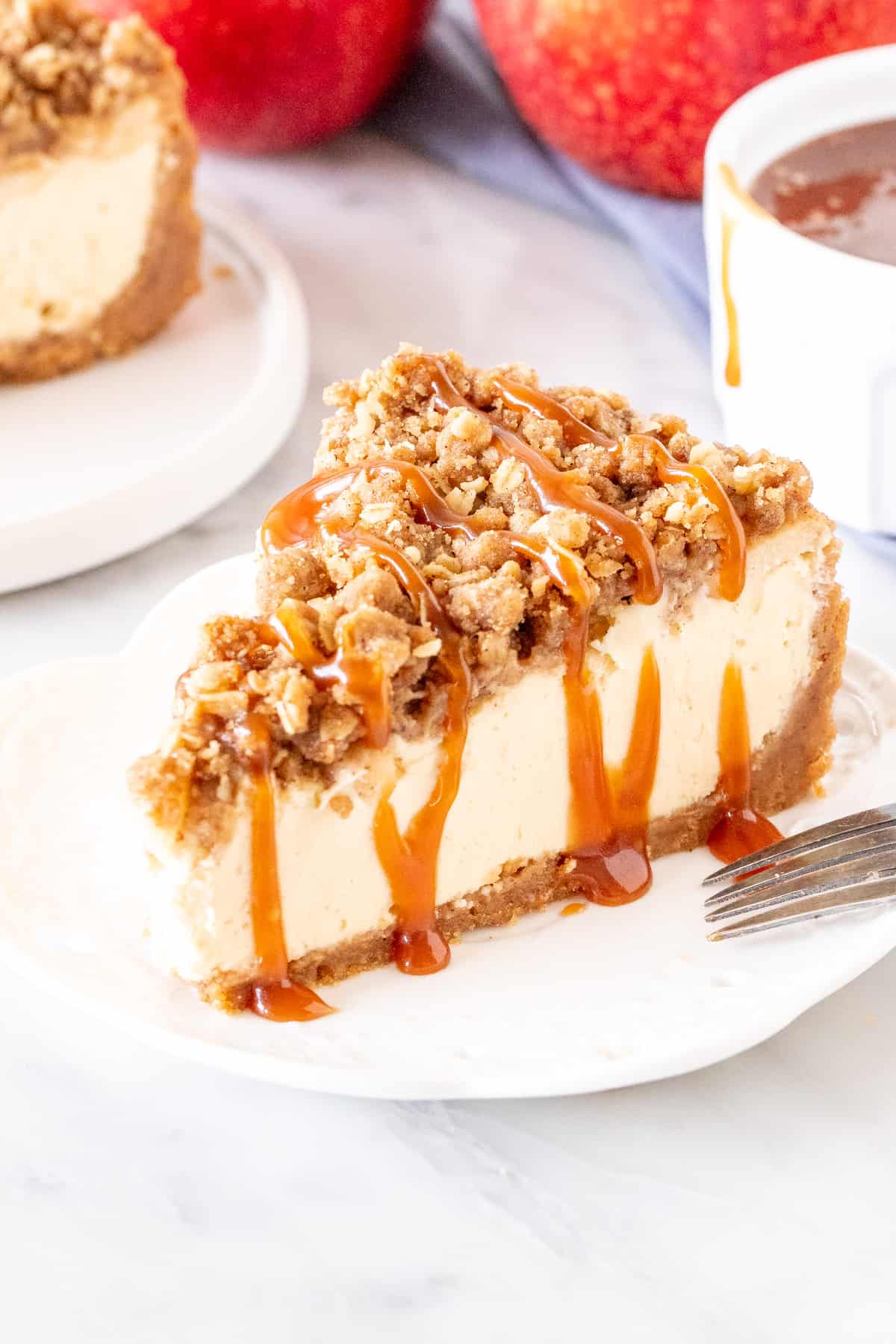 Slice of apple crisp cheesecake with a drizzle of caramel sauce.