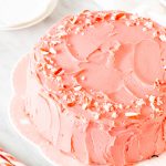 Chocolate cake frosted with pink peppermint frosting and decorated with crushed candy canes