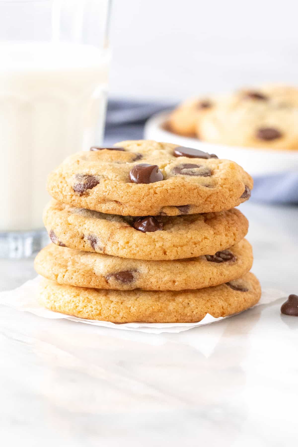 Stack of chocolate chip cookies with a glass of milk