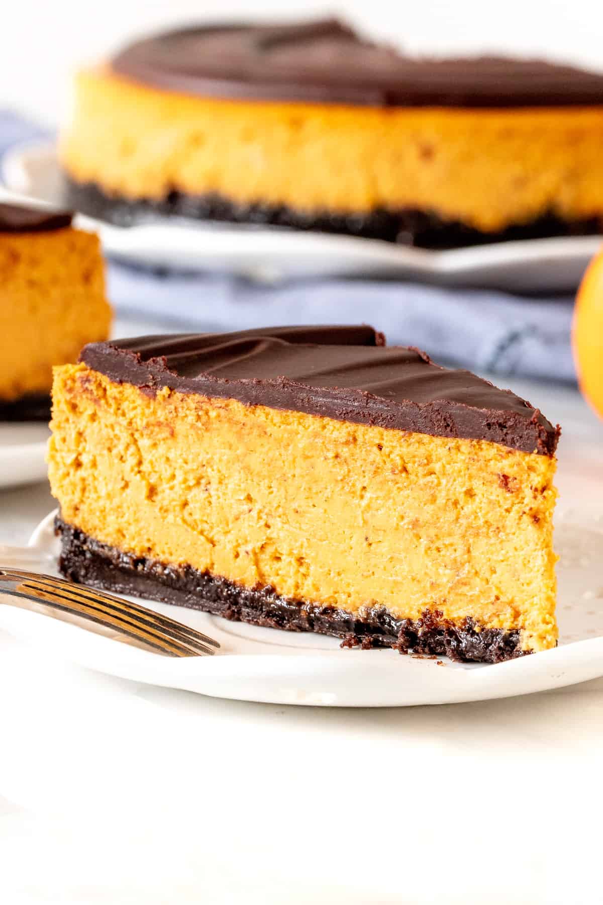 Slice of pumpkin cheesecake with chocolate ganache on top