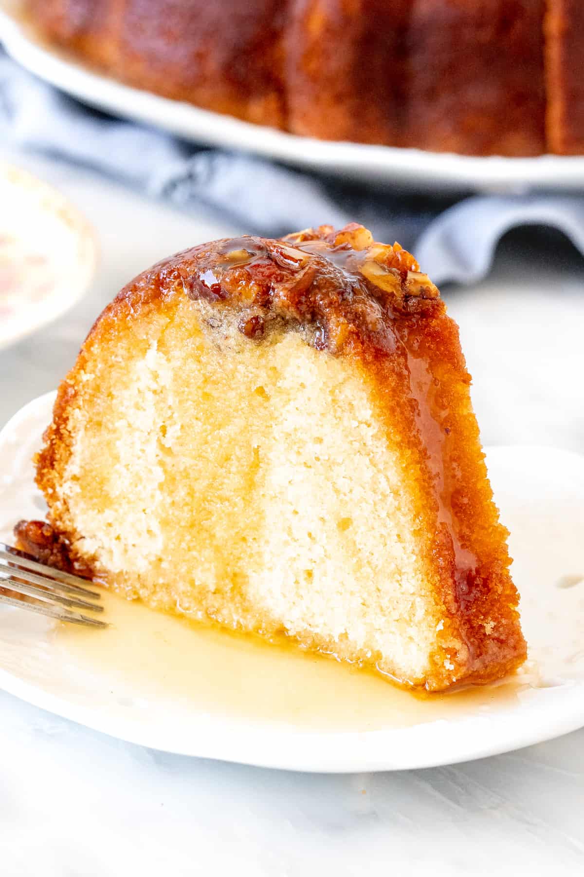 Slice of rum cake with rum sauce poured over the top.
