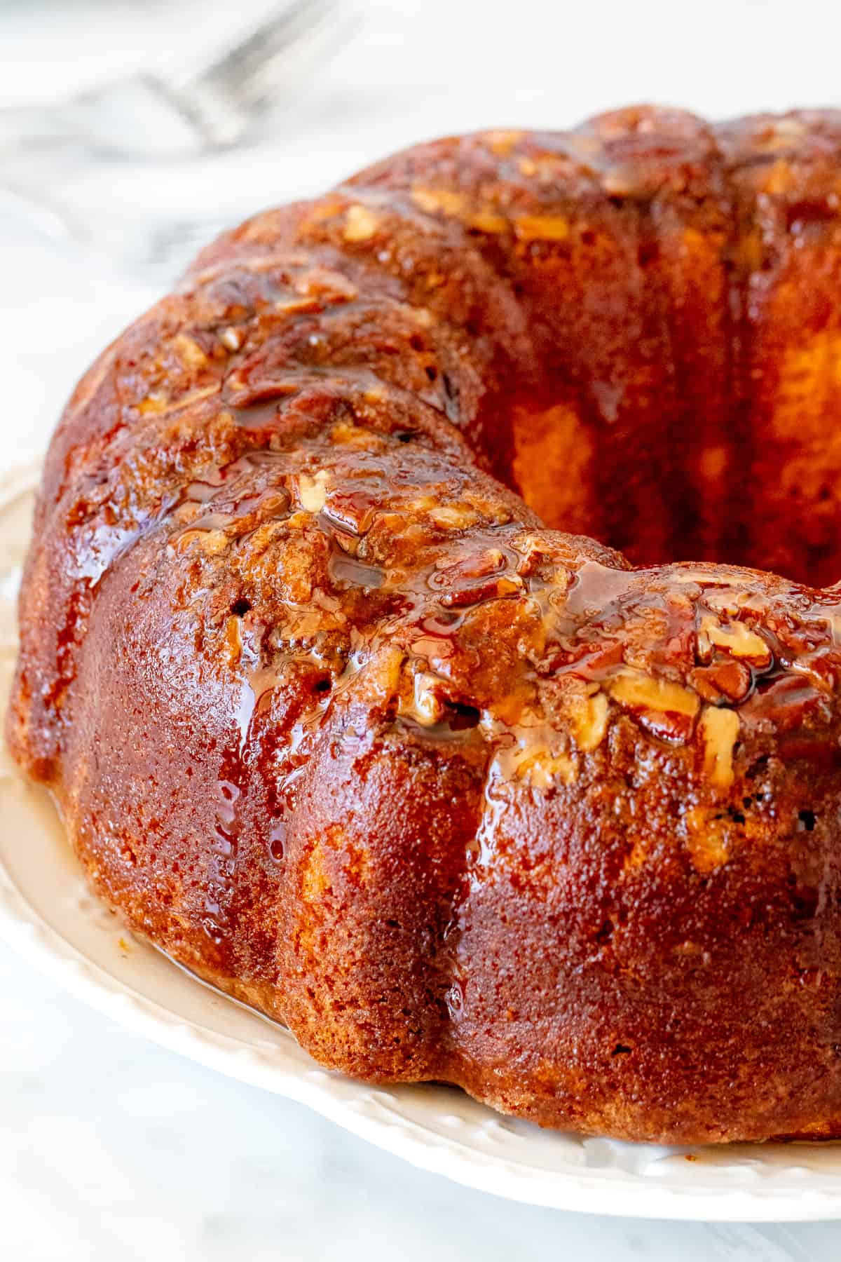 Rum-soaked cake made in a bundt pan with pecans.