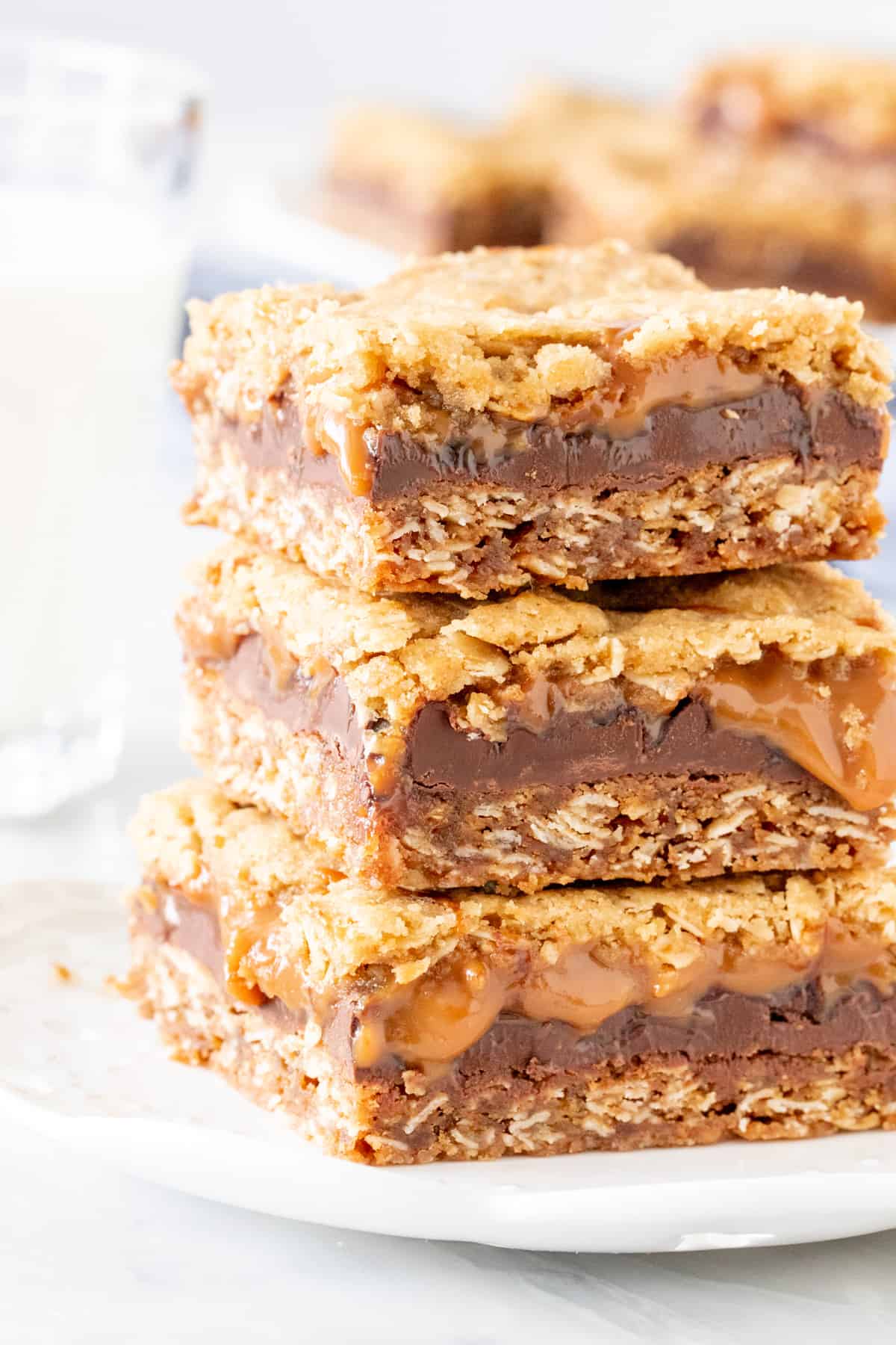 Stack of 2 caramel oatmeal bars with a glass of milk