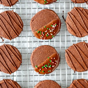 Chocolate cookies decorated with chocolate on a cooling rack