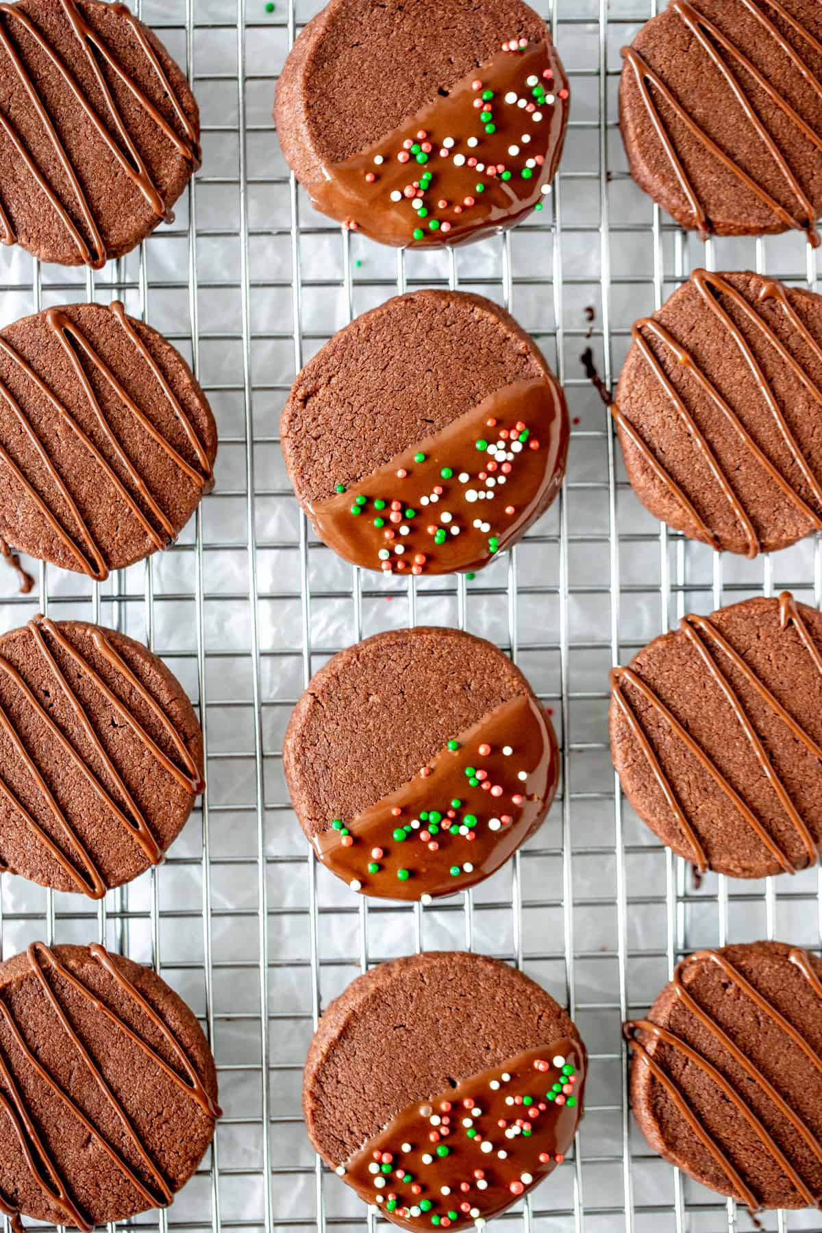 Chocolate cookies decorated with chocolate on a cooling rack