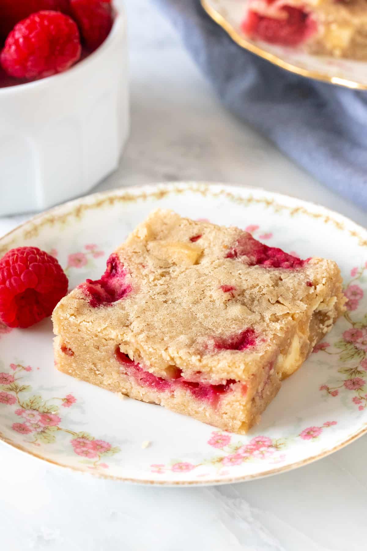 Blondie made with raspberries and white chocolate chunks on a plate