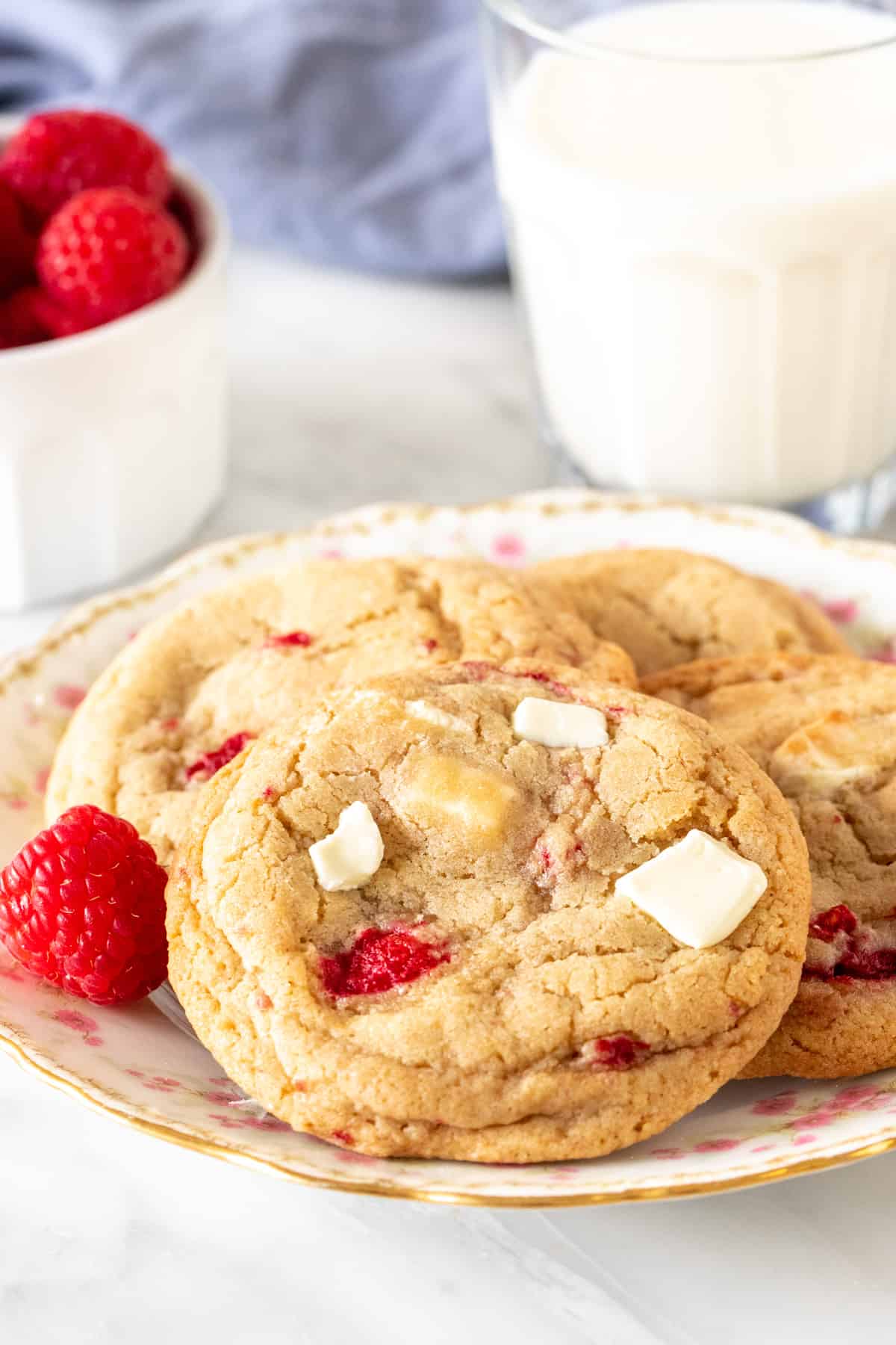 Plate of raspberry white chocolate chunk cookies with glass of milk
