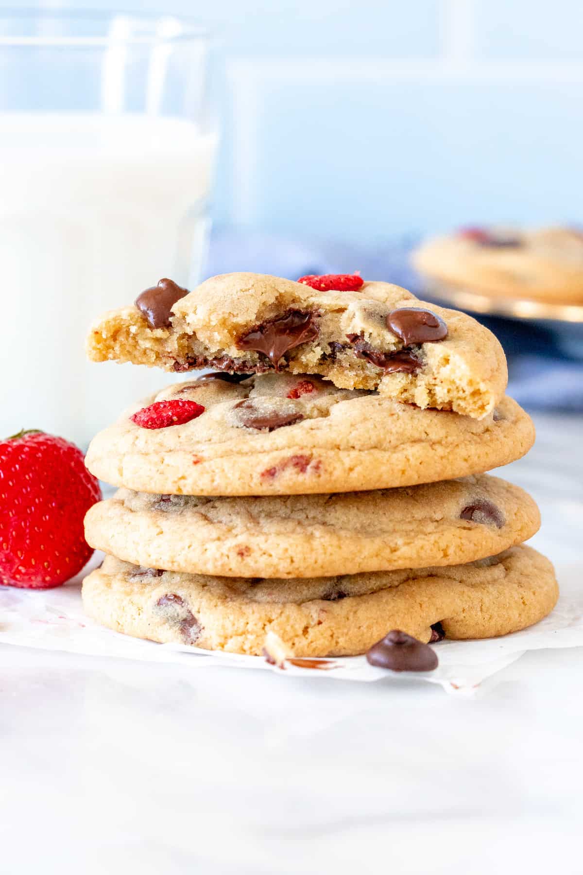 Stack of strawberry chocolate chip cookies, with top cookie broken in half