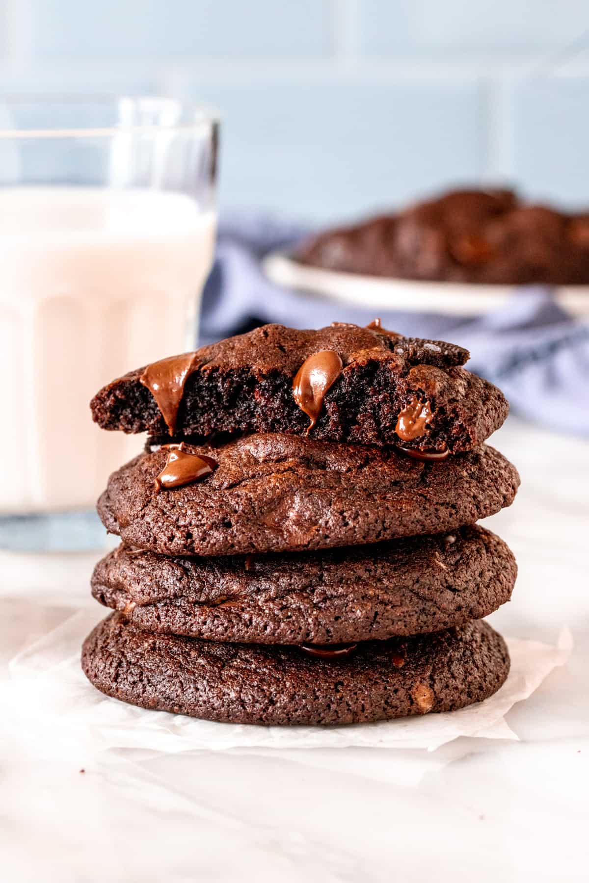Stack of chocolate Oreo cookies with the top cookie broken in half. 